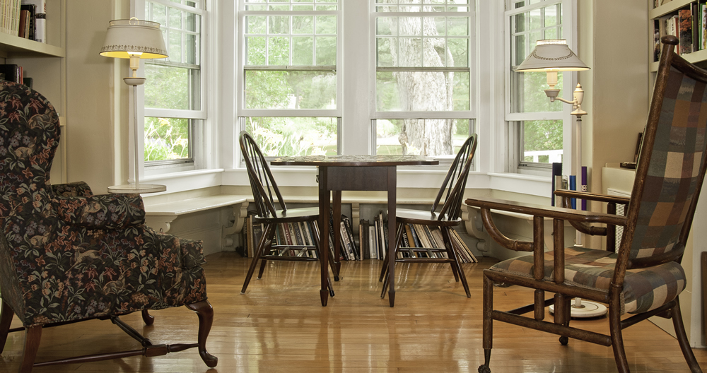 table with chairs in front of sunny windows