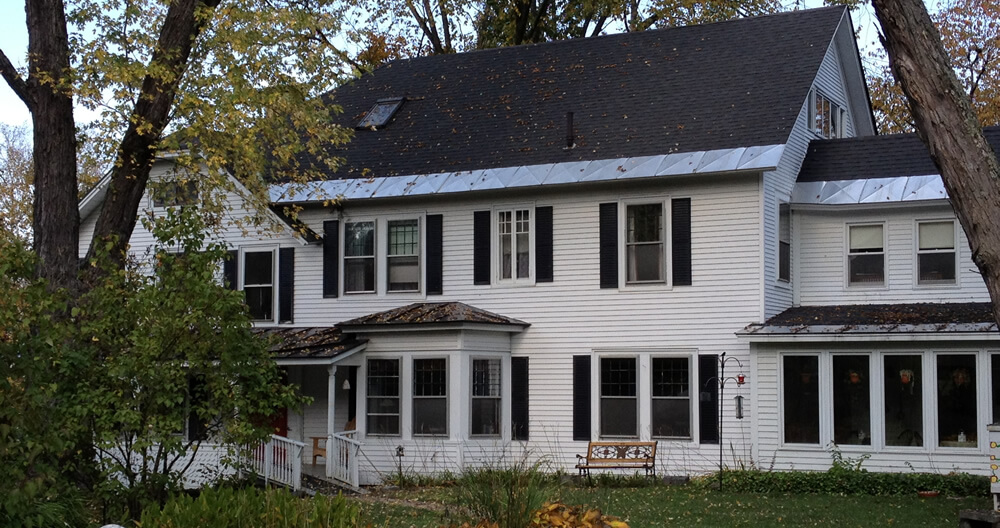 white inn with green grass and tree